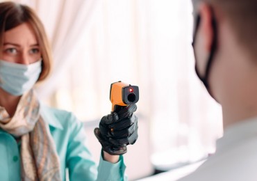 woman checking body temperature with thermal camera v2